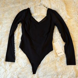 Lululemon black body suit with mesh. Brand new with tags never worn. Size 6